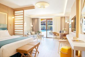 a hotel room with a bed and a living room at Anthemus Sea Beach Hotel and Spa in Elia