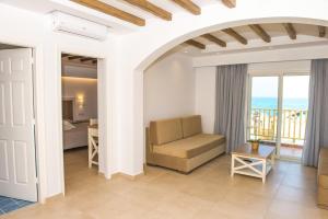 a living room with a couch and a view of the ocean at Mastichari Bay Hotel in Mastihari