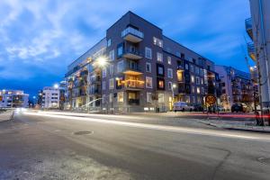 un bâtiment situé dans une rue de la ville la nuit dans l'établissement ApartDirect Linköping Vasastaden, à Linköping