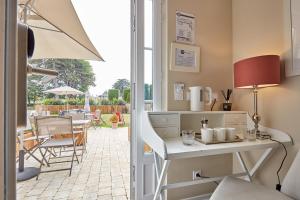 a kitchen with a table and chairs and a patio at Les Villas d'Arromanches, Teritoria in Arromanches-les-Bains