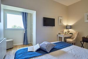 a bedroom with a bed and a window and a desk at Les Villas d'Arromanches, Teritoria in Arromanches-les-Bains