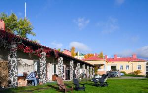 a person sitting on a bench outside of a house at Lossiranta Lodge in Savonlinna