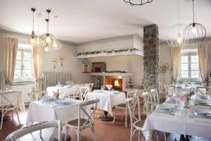 jadalnia z białymi stołami i krzesłami oraz kominkiem w obiekcie Villa Zelma w mieście Cantagrillo
