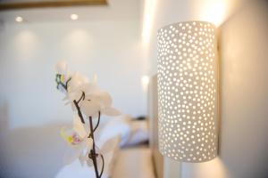 a white polka dot light with a flower in a vase at Mastichari Bay Hotel in Mastihari