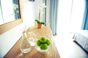 a table with a glass bottle and a bowl of green balls at Mastichari Bay Hotel in Mastihari
