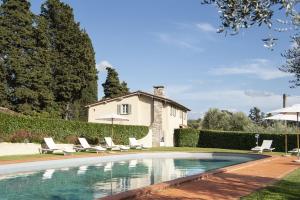 una piscina con sedie a sdraio e una casa di Villa Zelma a Cantagrillo