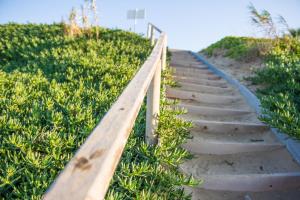 a wooden path on a hill with grass at Mastichari Bay Hotel in Mastihari