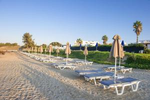 a row of beach chairs and umbrellas on a beach at Mastichari Bay Hotel in Mastihari