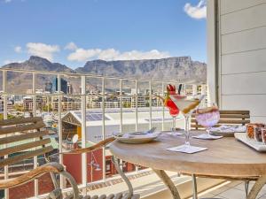 uma mesa com copos de vinho numa varanda com vista em Queen Victoria Hotel by NEWMARK na Cidade do Cabo