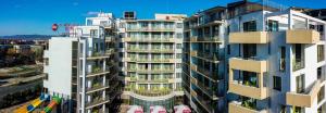 wysoki apartamentowiec z balkonami i parasolami w obiekcie Best Western PLUS Premium Inn w Słonecznym Brzegu