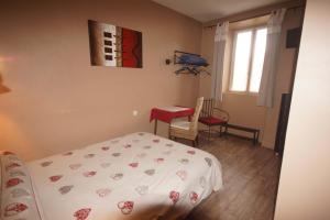 a bedroom with a bed and a desk and a window at Pension Saint Antoine in Briançon