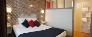 una camera da letto con un letto con cuscini rossi e neri di La Villa en L'île - 2 Piscines & Spa a Noirmoutier-en-l'lle