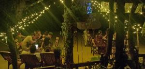 a group of people sitting at a party with lights at AbbA Marari Beach Villas & Homestay Mararikulam in Alleppey