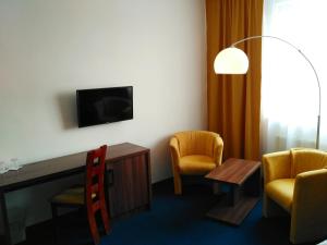 a room with two chairs and a table and a tv at Hotel Zobor in Nitra +12 photos