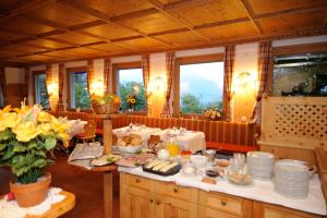 a dining room with a table with plates of food at Pension Laurin in Schenna