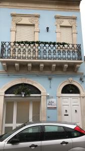 un'auto parcheggiata di fronte a un edificio con balcone di La Casa del Liberty a Vittoria