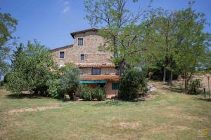 an old stone house with trees in front of it at Terre di Melazzano - Le Case di Patrizia in Greve in Chianti