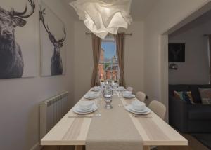 una mesa de comedor con platos y copas de vino en The BREWery Apartment en Sileby