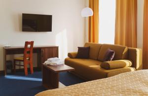 a hotel room with a couch and a desk at Hotel Zobor in Nitra