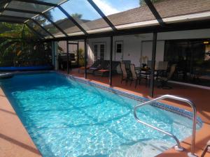 a swimming pool on a patio with a table and chairs at Villa Angel's Haven in Cape Coral