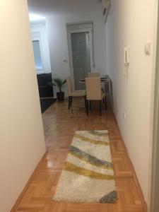 a living room with a table and a rug on the floor at Apartman PEŠAČKA ZONA in Šabac