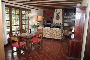 ein Wohnzimmer mit einem Tisch, Stühlen und einem Sofa in der Unterkunft FINCA EL PEDREGAL in Valsequillo de Gran Canaria