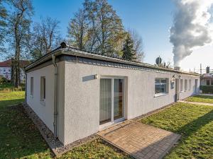 una pequeña casa blanca en un patio con humo en Pension zum Bergmann, en Böhlen