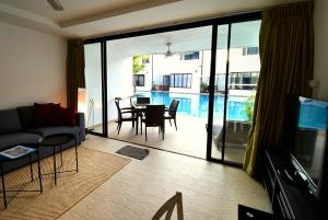 een woonkamer met een bank en een tafel bij Sai Naam Lanta Residence SHA Plus in Koh Lanta