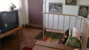 ein Wohnzimmer mit einem TV und einem Stuhl in der Unterkunft Tuule 1 Home Accommodation in Kuressaare