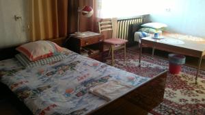 ein Schlafzimmer mit einem Bett, einem Tisch und einem Stuhl in der Unterkunft Tuule 1 Home Accommodation in Kuressaare