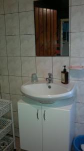 ein Badezimmer mit einem weißen Waschbecken und einem Spiegel in der Unterkunft Tuule 1 Home Accommodation in Kuressaare