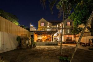 une grande maison avec un patio la nuit dans l'établissement Baan Ing Ping, à Chiang Mai