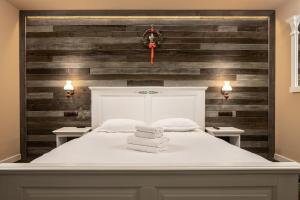 a bedroom with a white bed and wooden walls at Vila Hora cu Brazi in Zărneşti