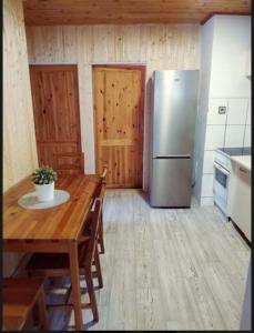 a kitchen with a wooden table and a refrigerator at Chata u Brodu in Deštné v Orlických horách