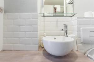 ein Badezimmer mit einem großen weißen Waschbecken und einem WC in der Unterkunft Small Is Beautiful Ideally Located Sleeps 4 in Paris