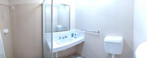 a bathroom with a sink and a mirror at Toukley Motel in Toukley