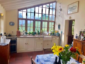 una cocina con fregadero y una mesa con flores en Cilffriw Farm, en Neath