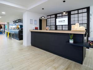 a bar in a restaurant with a counter and chairs at Campanile PRIME - Marseille Aubagne in Aubagne +17 photos