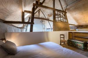 a bedroom with a white bed and a chair at Aan de Holle Weg. Zeer landelijk gelegen verbouwde stal tot woning in Nuth