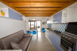a living room with a couch and a kitchen at A.I.R. Villa Marinedda in Isola Rossa