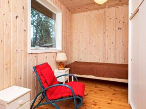 Habitación con silla roja y cama en 8 person holiday home in Frederiksv rk en Frederiksværk