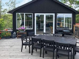 Une table et des chaises en bois sont disponibles sur la terrasse. dans l'établissement 4 person holiday home in KERSBERGA, à Åkersberga