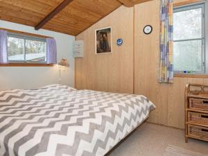 um quarto com uma cama e um relógio na parede em 4 person holiday home in Fan em Fanø