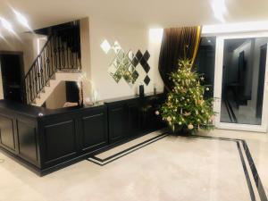 a christmas tree in a living room with a staircase at Vila JŪRALUX in Palanga