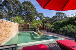 a swimming pool with an umbrella on a patio at De Sarann Villa in Siem Reap