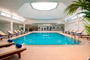 a large indoor pool with chairs and a swimming pool at Royal Apollonia by Louis Hotels in Limassol
