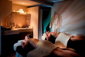a couple of people laying in beds in a room at Royal Apollonia by Louis Hotels in Limassol