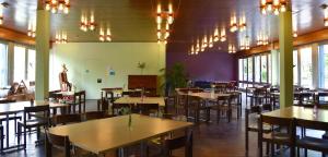 a dining room with tables and chairs and chandeliers at Hostel 77 Bern in Bern