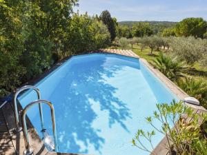 a large swimming pool in a yard with trees at Modern holiday home with private pool in Brignoles