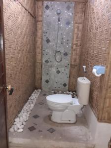 a bathroom with a toilet and a rock wall at Club Resort MATAHARI in Gili Trawangan